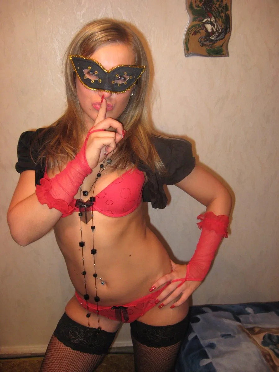 UNE FEMME MATURE en tenue sexy rouge elle porte un loup pour une soirée échangiste